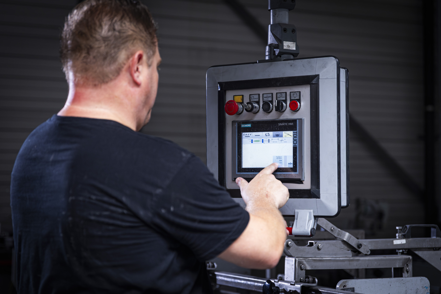 Productiemedewerker werkt aan automatische lijn voor draadopmaak